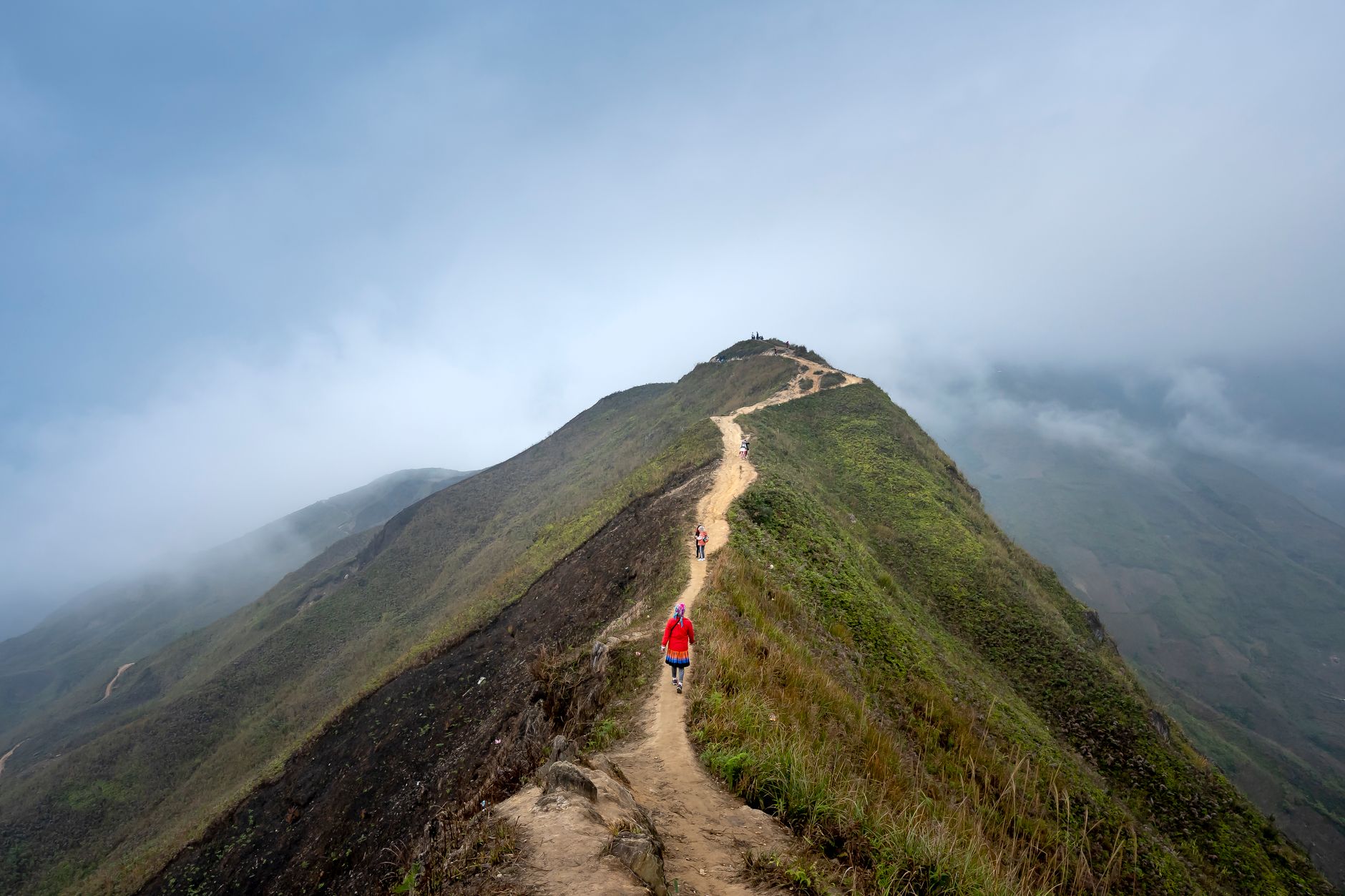 Small expedition group walking along volcanic mountain ridge